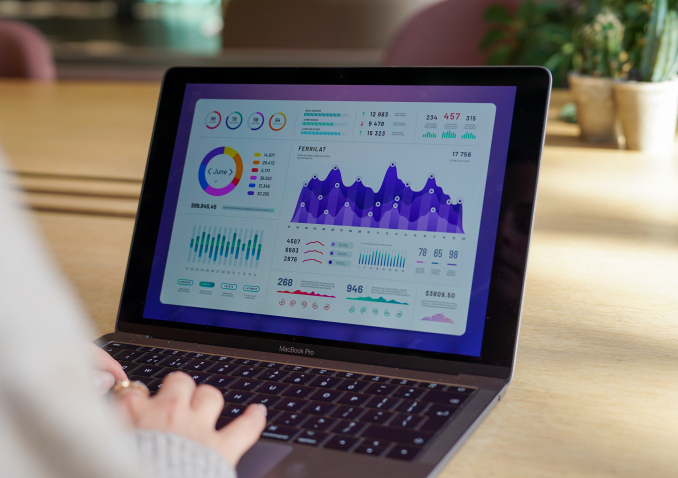 Lady works on laptop looking at financial graphs